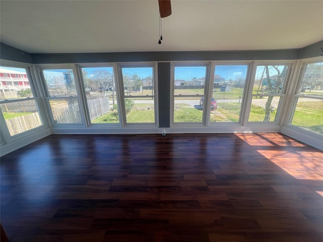 unfurnished sunroom featuring a healthy amount of sunlight and a ceiling fan