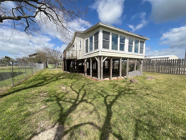 rear view of house with a yard and a fenced backyard