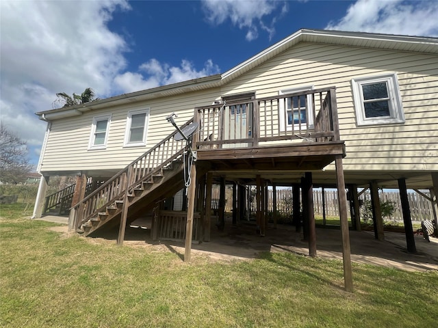 rear view of property with a deck, stairway, and a yard