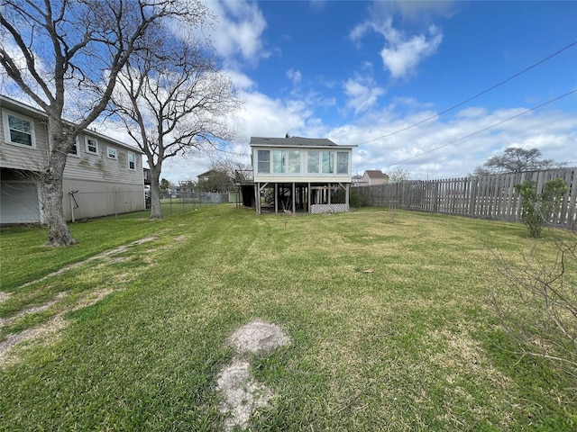 view of yard with a fenced backyard and a sunroom