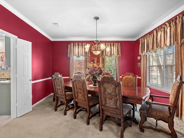 dining area with visible vents, crown molding, baseboards, light colored carpet, and a chandelier