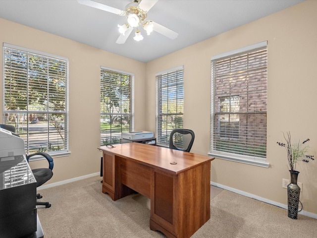 office space with light colored carpet, baseboards, and ceiling fan