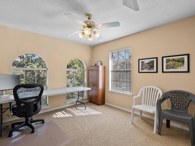 carpeted office featuring a textured ceiling, baseboards, and ceiling fan