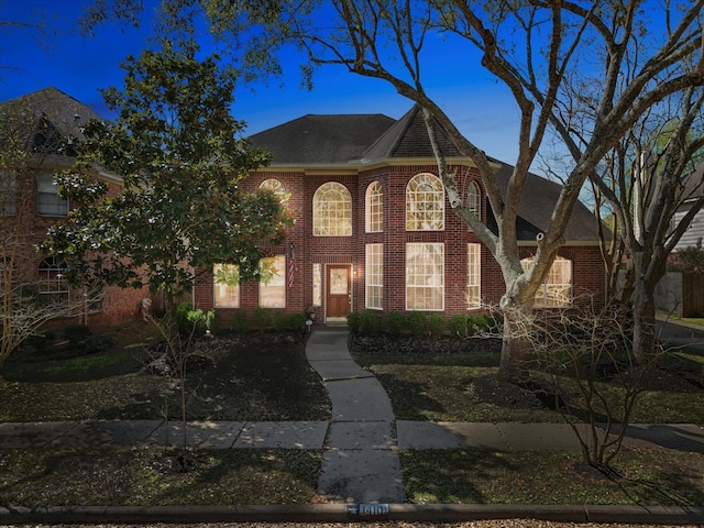 view of front of home featuring brick siding and a shingled roof