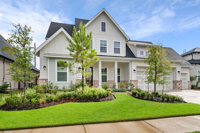 view of front of home with board and batten siding, a front yard, concrete driveway, and brick siding