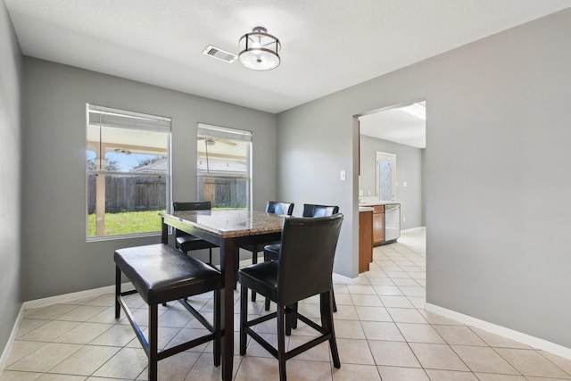 dining area featuring light tile patterned floors, visible vents, and baseboards