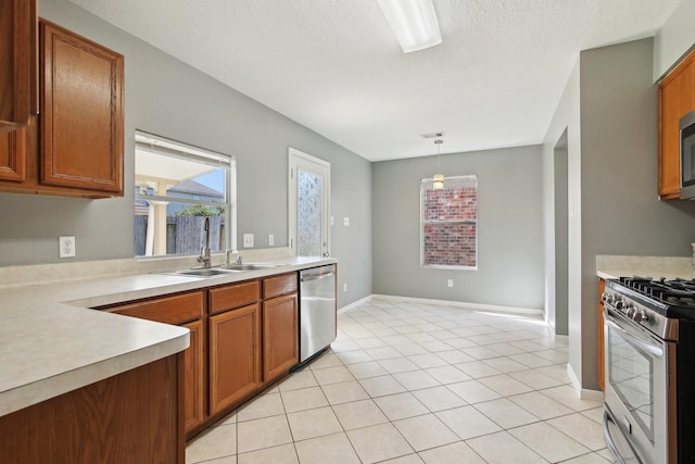 kitchen with light countertops, brown cabinets, and appliances with stainless steel finishes