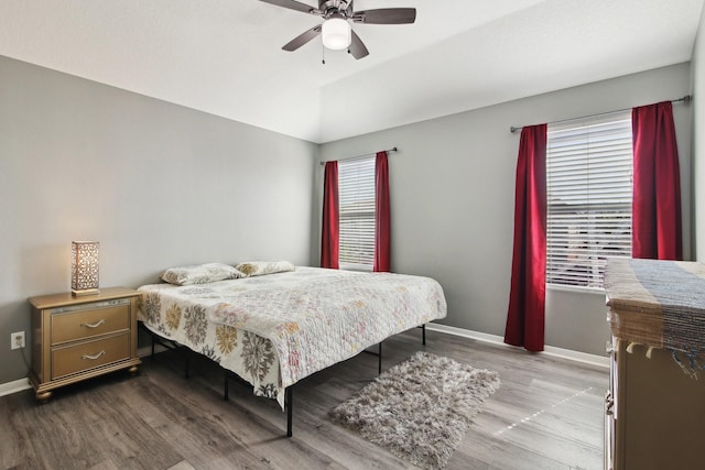 bedroom featuring ceiling fan, baseboards, lofted ceiling, and wood finished floors