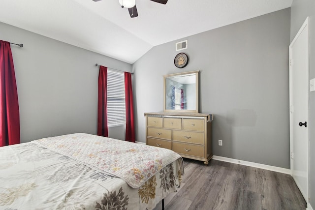 bedroom with visible vents, wood finished floors, baseboards, lofted ceiling, and ceiling fan