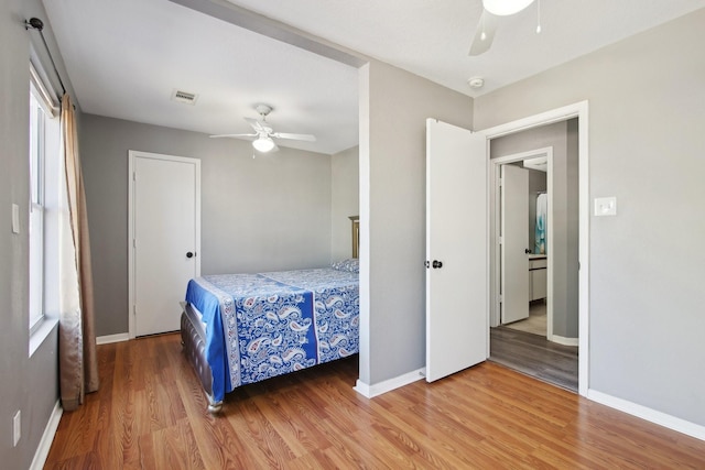 bedroom featuring visible vents, a ceiling fan, baseboards, and wood finished floors