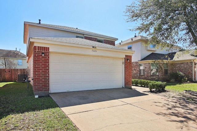 garage featuring concrete driveway, cooling unit, and fence