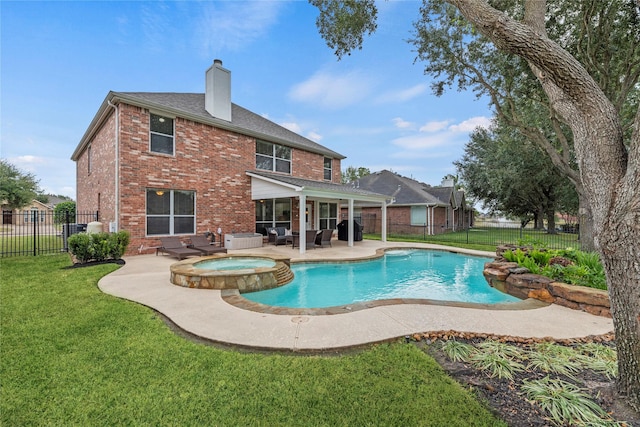 view of swimming pool featuring a patio area, a pool with connected hot tub, a lawn, and a fenced backyard