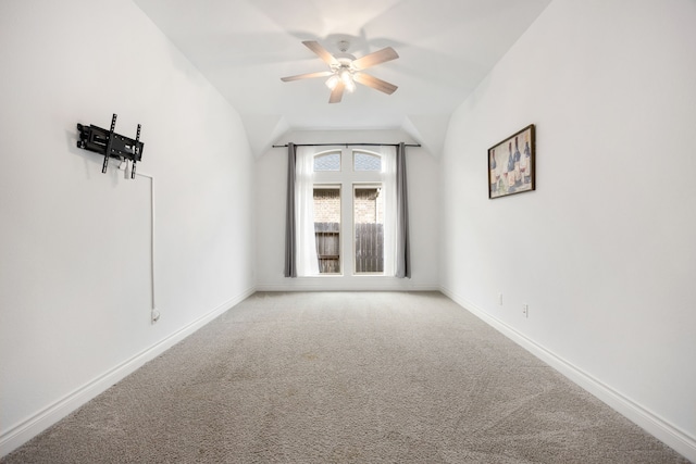 spare room featuring baseboards, light colored carpet, ceiling fan, and vaulted ceiling