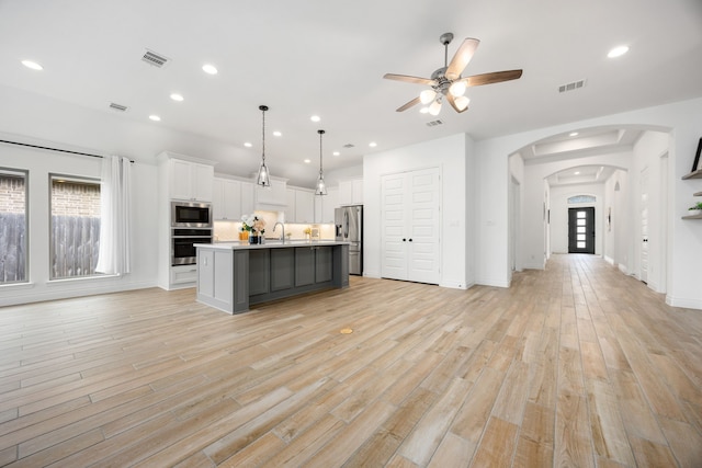 kitchen with visible vents, light wood-style flooring, open floor plan, appliances with stainless steel finishes, and light countertops