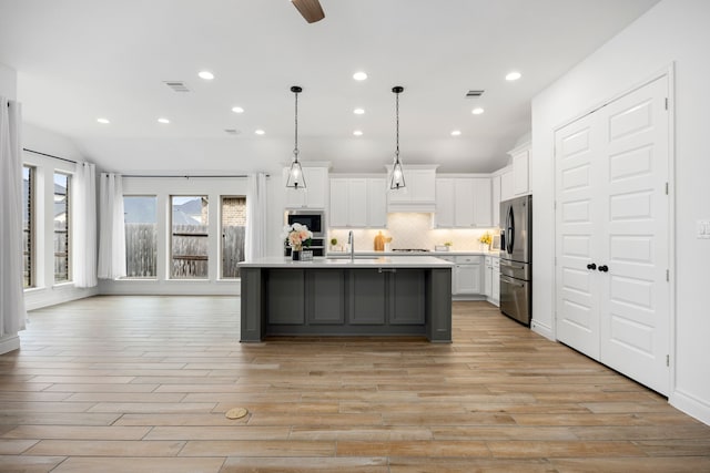 kitchen featuring visible vents, light countertops, appliances with stainless steel finishes, white cabinetry, and tasteful backsplash