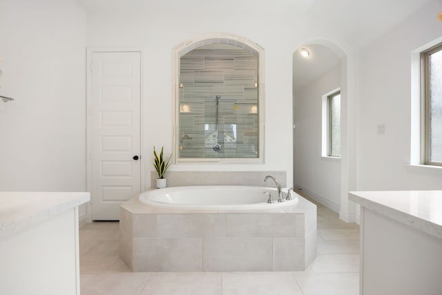 full bathroom featuring tile patterned floors, tiled shower, a bath, and vanity