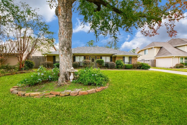 ranch-style house with brick siding, a front yard, and fence