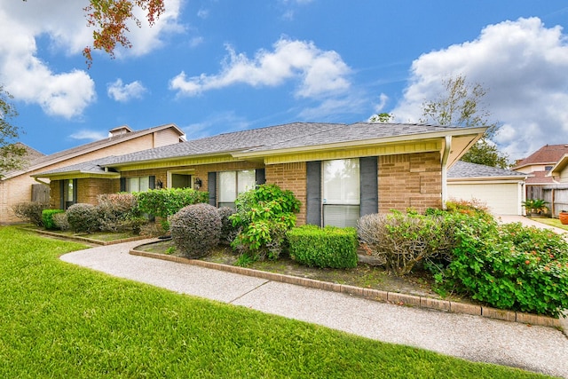 single story home featuring a garage, brick siding, roof with shingles, and a front lawn