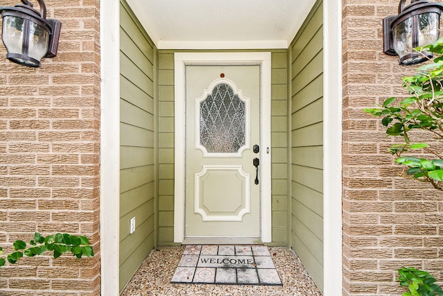 view of exterior entry featuring brick siding