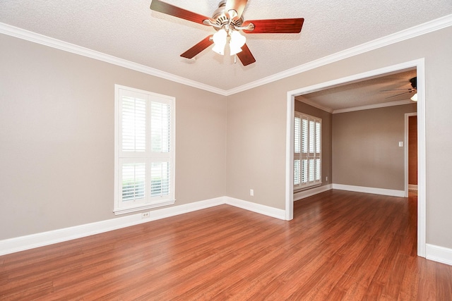 empty room with a wealth of natural light, a textured ceiling, and wood finished floors