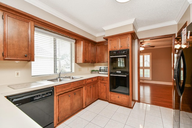 kitchen with plenty of natural light, black appliances, light countertops, and a sink