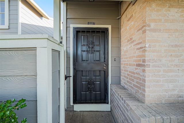 entrance to property featuring brick siding