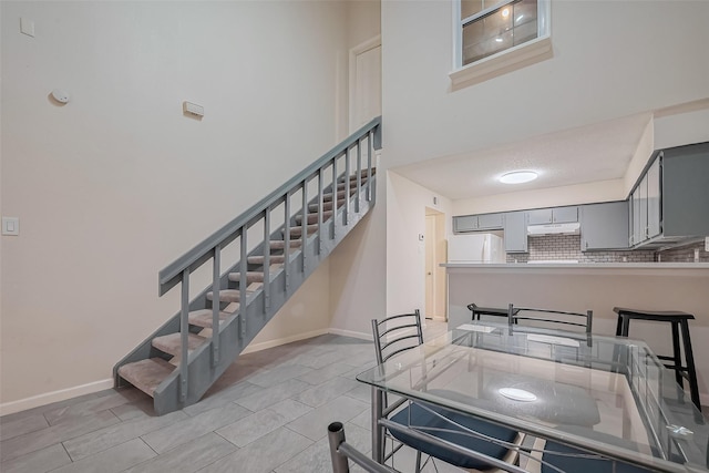 interior space featuring a high ceiling and baseboards