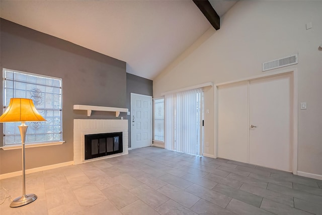 unfurnished living room featuring visible vents, baseboards, beam ceiling, a fireplace, and high vaulted ceiling