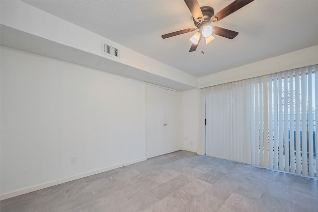 unfurnished room featuring visible vents, baseboards, and ceiling fan