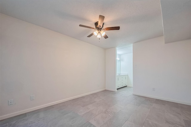unfurnished room with baseboards, a ceiling fan, and a textured ceiling