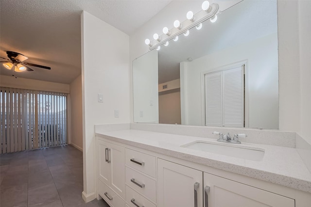 bathroom with vanity, tile patterned floors, a ceiling fan, and a textured ceiling