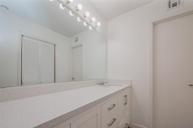 bathroom featuring vanity, baseboards, and visible vents