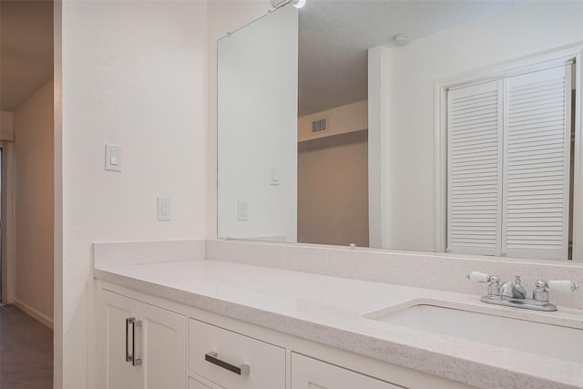 bathroom with visible vents, a textured ceiling, and vanity