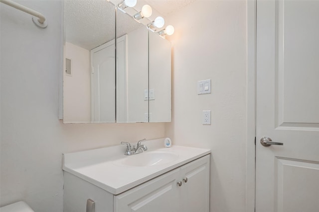 bathroom featuring a textured ceiling and vanity