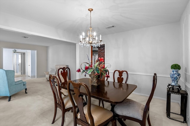 dining room with light carpet, visible vents, a chandelier, and baseboards