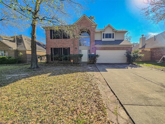 traditional-style house with brick siding, a front lawn, concrete driveway, and a garage