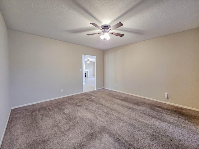 carpeted empty room featuring a textured ceiling, baseboards, and a ceiling fan