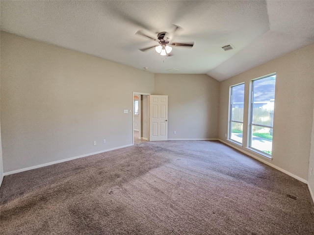 carpeted empty room featuring visible vents, lofted ceiling, a textured ceiling, baseboards, and ceiling fan