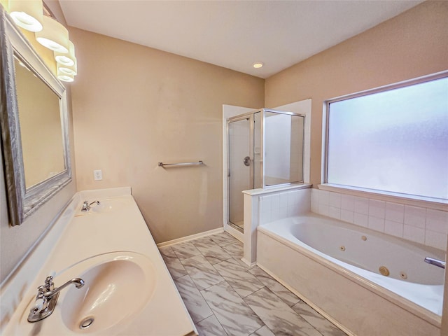 bathroom featuring marble finish floor, a jetted tub, a shower stall, and a sink