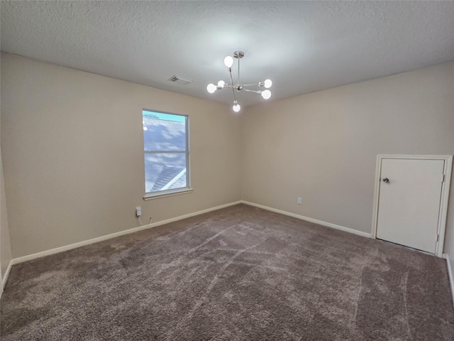 carpeted empty room featuring a notable chandelier, visible vents, baseboards, and a textured ceiling