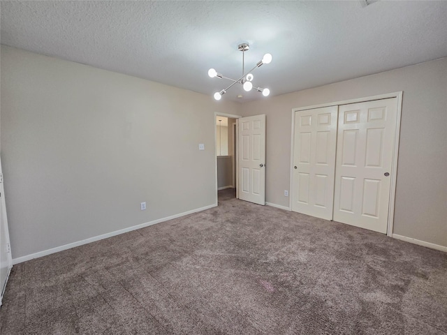 unfurnished bedroom with a closet, a textured ceiling, baseboards, and carpet floors