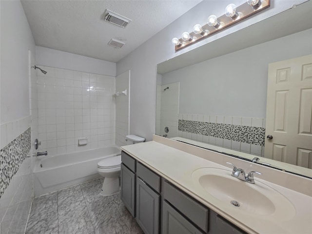 full bathroom featuring vanity, toilet, visible vents, and a textured ceiling