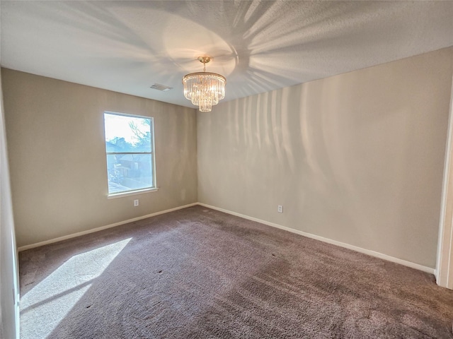 carpeted empty room featuring a notable chandelier, visible vents, a textured ceiling, and baseboards