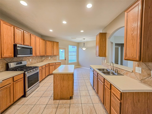 kitchen with a sink, a kitchen island, stainless steel appliances, light countertops, and light tile patterned floors