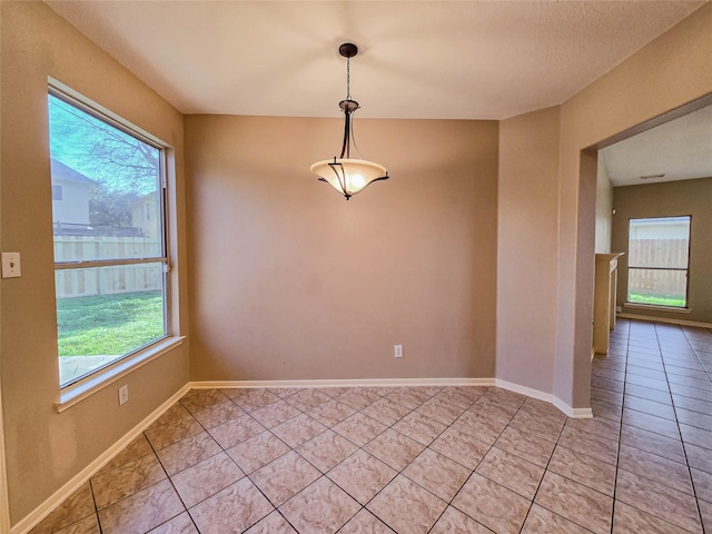 unfurnished room featuring light tile patterned floors and baseboards