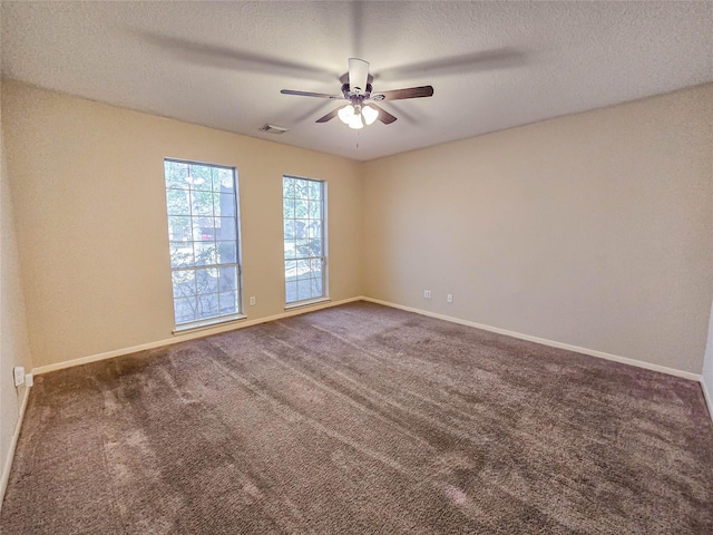 carpeted spare room with visible vents, baseboards, and a textured ceiling