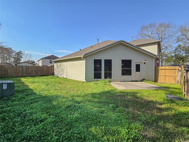 back of house with a patio area, a lawn, and a fenced backyard