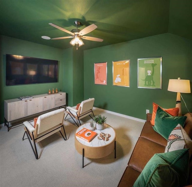 living area with vaulted ceiling, baseboards, a ceiling fan, and carpet floors