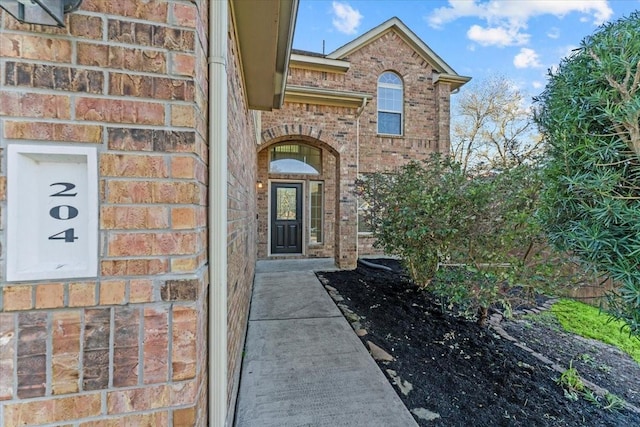 entrance to property featuring brick siding