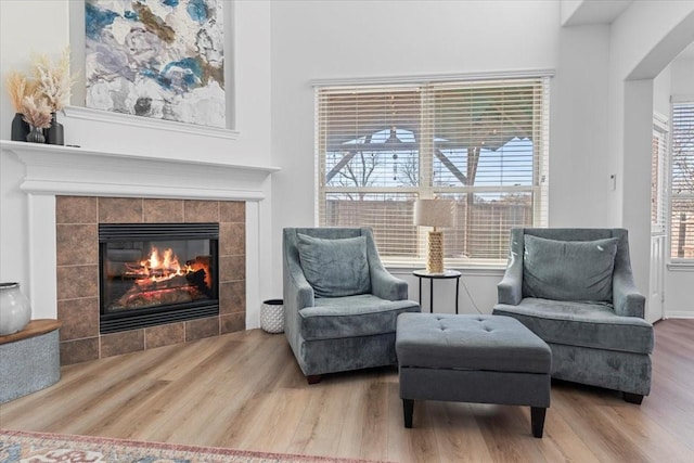 sitting room with wood finished floors and a tile fireplace